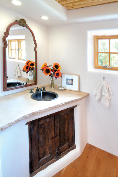 Richard and Betsy found an antique cabinet door and mirror at a local shop and used them to add rustic character to the guest bathroom. The vanity countertop is stone; the sink, hammered copper.